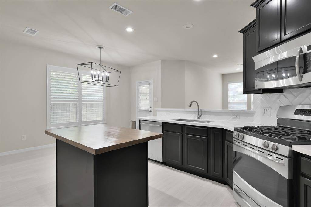 Family room features hardwood flooring, gas log fireplace, recessed lighting
