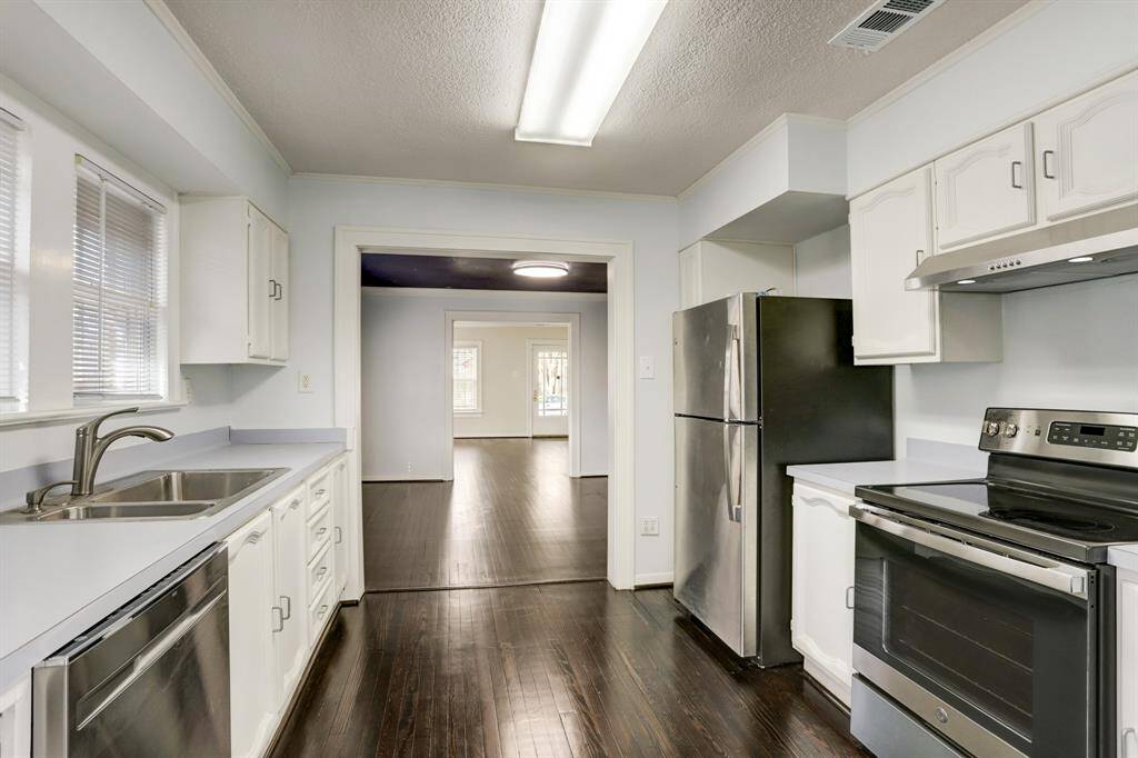 View of the kitchen showing the flow into the dining and living areas.