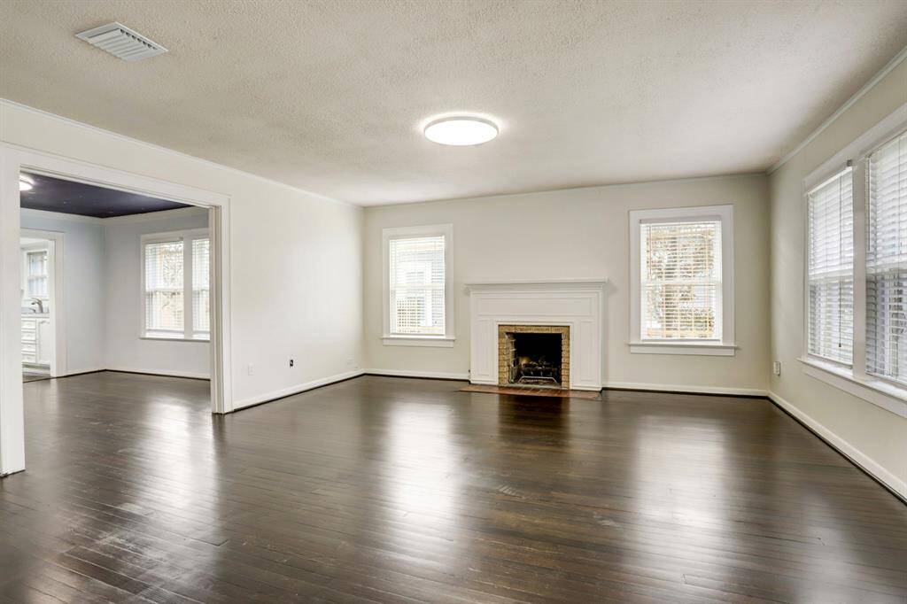 The living room is very spacious with plenty of natural light. The hardwood floors and original fireplace add a vintage charm.