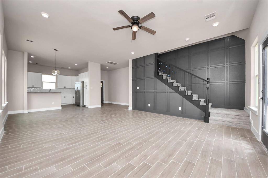 A spacious, open-concept living area with modern tile flooring and plenty of natural light.