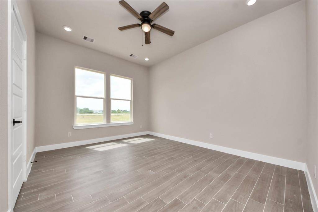 A modern, two-story home with a spacious driveway and a two-car garage. The exterior features a mix of light siding and dark accents, complemented by a neatly landscaped front path. Offering a serene and inviting atmosphere.