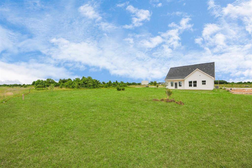 A modern, two-story home with a spacious driveway and a two-car garage. The exterior features a mix of light siding and dark accents, complemented by a neatly landscaped front path. Offering a serene and inviting atmosphere.