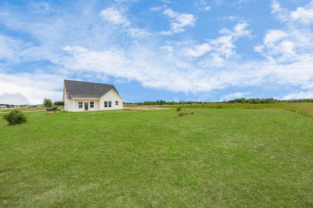 A modern, two-story home with a spacious driveway and a two-car garage. The exterior features a mix of light siding and dark accents, complemented by a neatly landscaped front path. Offering a serene and inviting atmosphere.