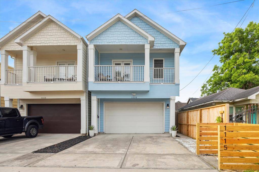 The front of the home shows the balcony access from the primary bedroom and side gate to access the entrance to the home.