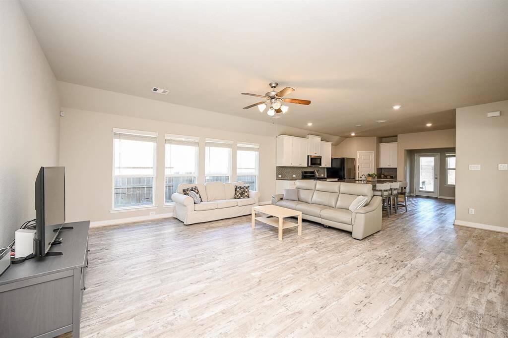 Spacious open-concept living area with abundant natural light, modern kitchen, and stylish flooring. Ideal for entertaining and family living.