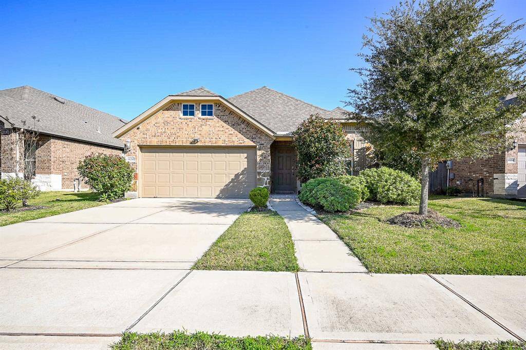 Features a welcoming entrance, lush landscaping, and a spacious driveway. Ideal for comfortable suburban living.