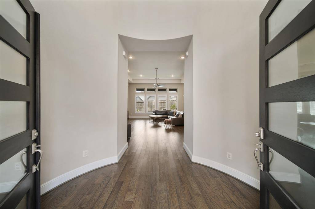 The gracefully curved foyer, adorned with rich hardwood floors, offers a grand and inviting welcome, setting the stage for the refined elegance found throughout the home.