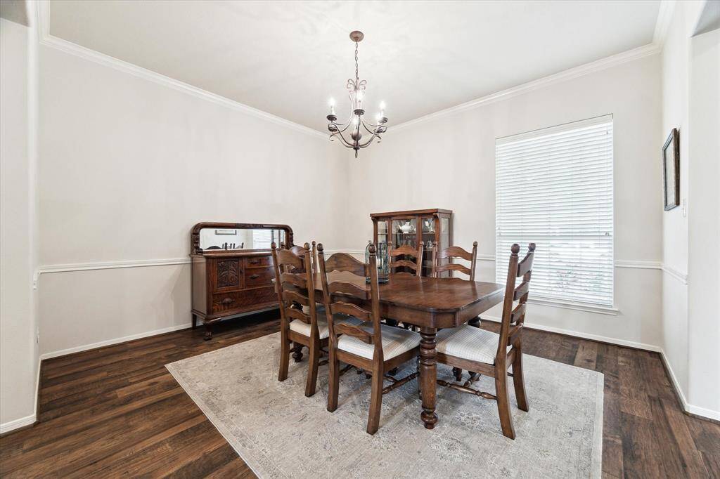 Gather everyone around your table to honor old traditions and create the new. This elegant formal dining room provides the ideal backdrop for everything from casual family meals to lavish dinner parties, with wood-look tile flooring, rich millwork, and a stylish chandelier.