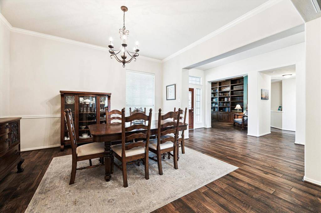 Elevate every meal in this formal dining room, where beautiful flooring, classic millwork, and a chic chandelier come together to create a warm and inviting space, perfect for weeknight dinners or holiday celebrations.