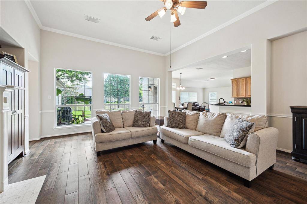 A wall of windows fills the family room with natural light and frames serene views of the backyard and lake, creating a bright and peaceful space that seamlessly connects indoor and outdoor living.
