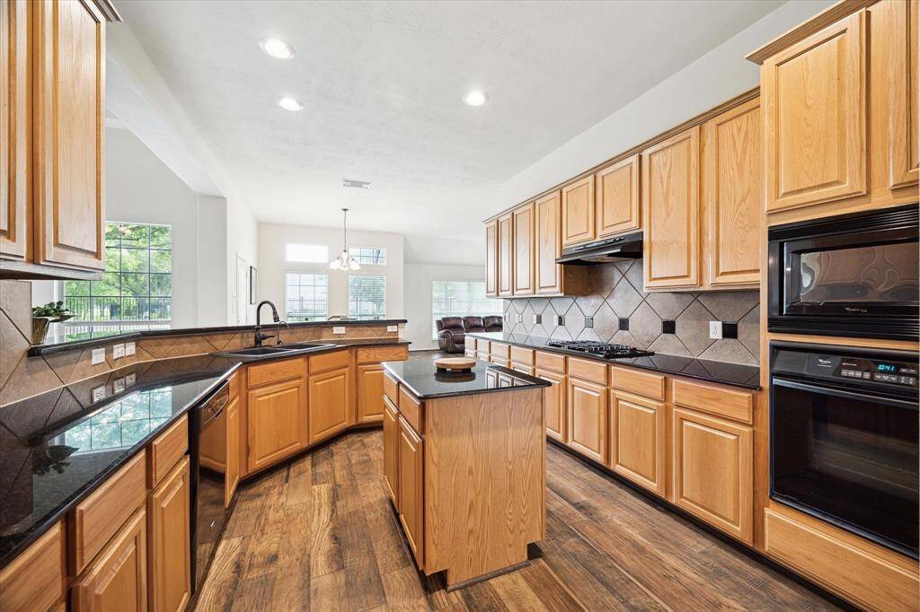 Enjoy cooking with a view in this well-appointed kitchen, featuring built-in appliances, a central island perfect for prep work, and a wraparound breakfast bar with seating that keeps everyone connected.