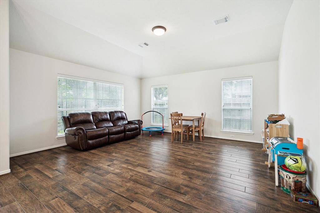 This bright and versatile flex space sits just off the casual dining area and kitchen, making it perfect for a sunroom, den, or playroom. Featuring beautiful flooring and scattered windows that fill the room with natural light, this adaptable space easily fits your everyday needs.