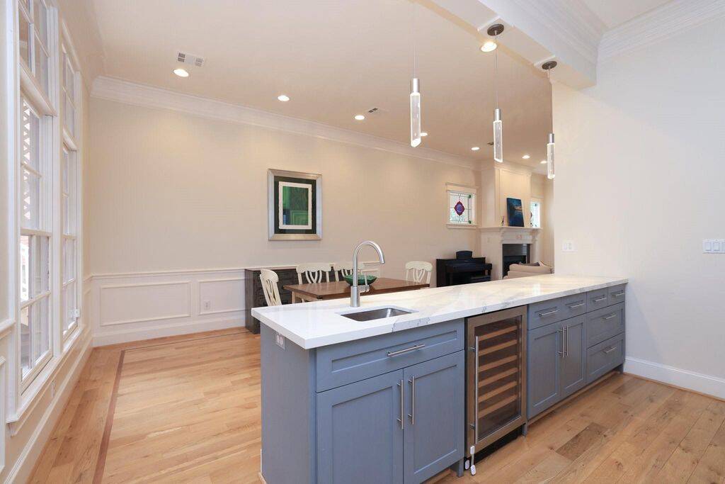 A view of the island towards the dining room and the windows to the left. Whole house has high ceilings and is bathed in natural light.