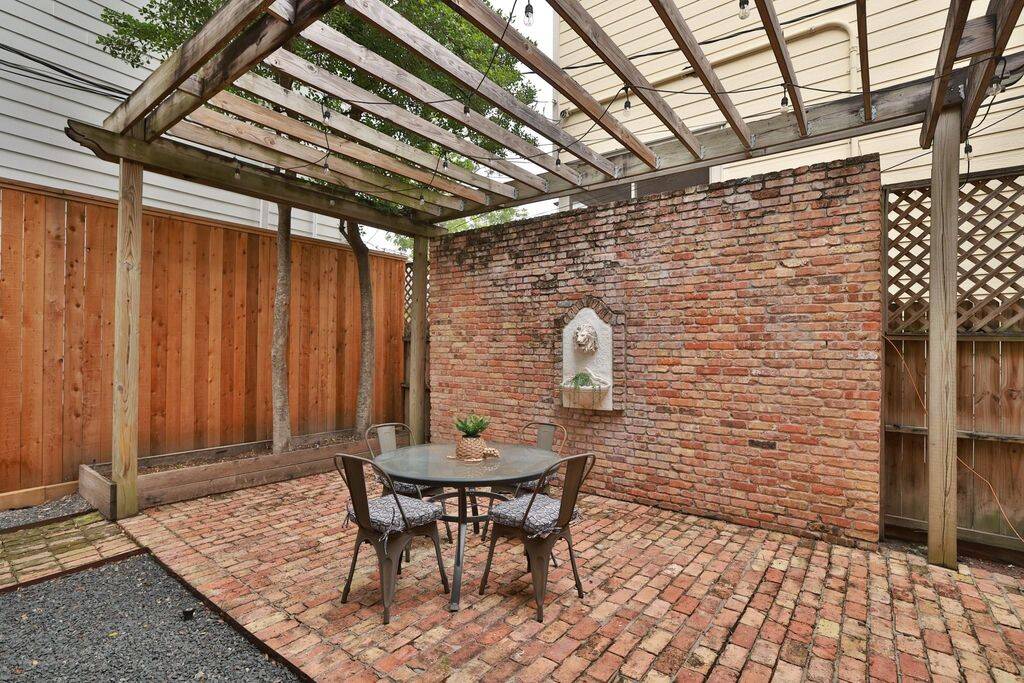 New Orleans style brick patio with built-in concrete fountain and portico. Made for peaceful nights with a glass of wine or gatherings with friends!