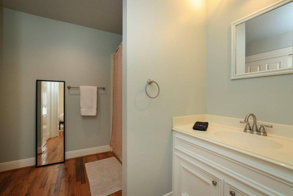 Large bathroom with a tub/shower, large vanity, and a double closet.