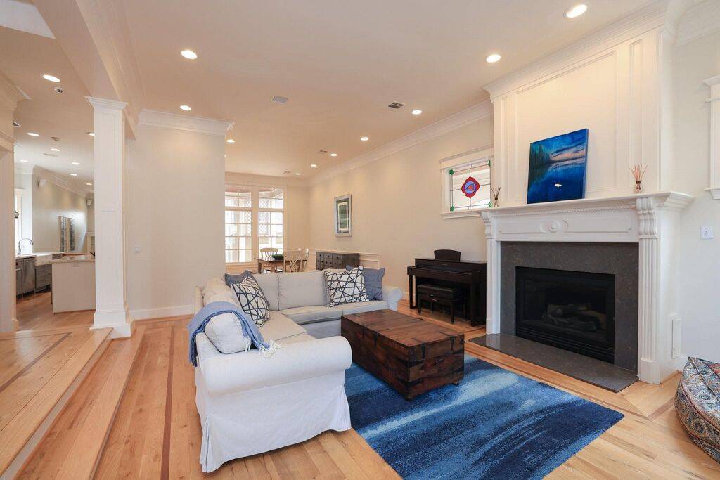 Enter to find a large living room with fireplace, stained glass windows to each side, real hardwood floors throughout the home, and wood shudders.