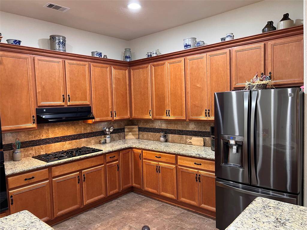 GRANITE COUNTERS AND A 5-BURNER COOKTOP MAKE COOKING AND SERVING A BREEZE.