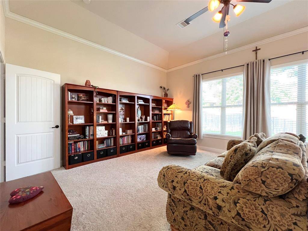 PRIMARY SUITE FEATURING A SITTING SPACE WITH A GARDEN VIEW.