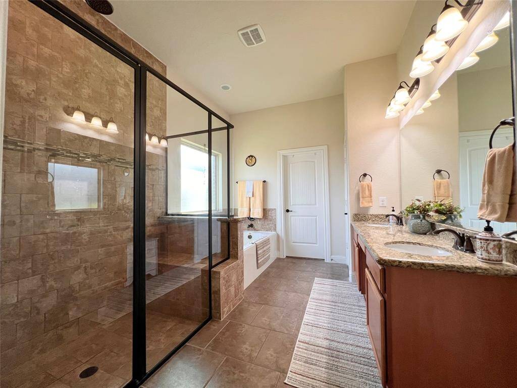 PRIMARY ENSUITE WITH GLASS SURROUND SHOWER, SOAKING TUB, ACCESS TO THE MASTER WALK-IN CLOSET, A LINEN CLOSET AND PRIVATE WATER CLOSET.