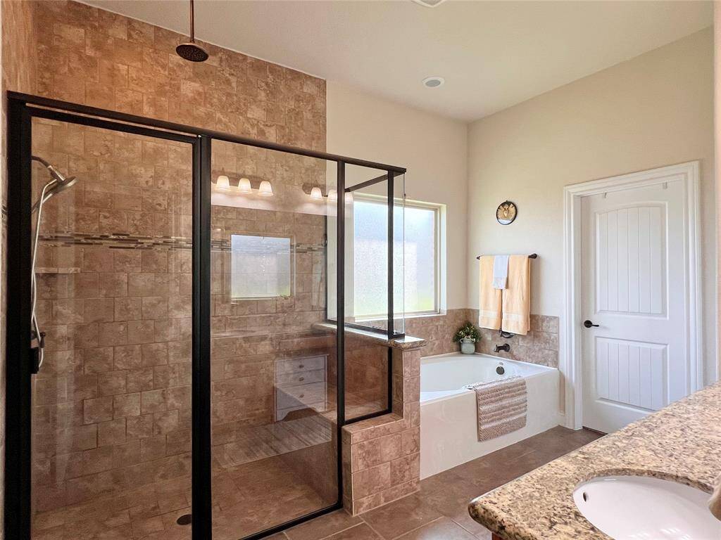SHOWER FEATURES 2 SHOWERHEADS AND A BUILT IN SEAT.  OBSCURED PRIVACY GLASS WINDOW OVER THE SOAKING TUB.