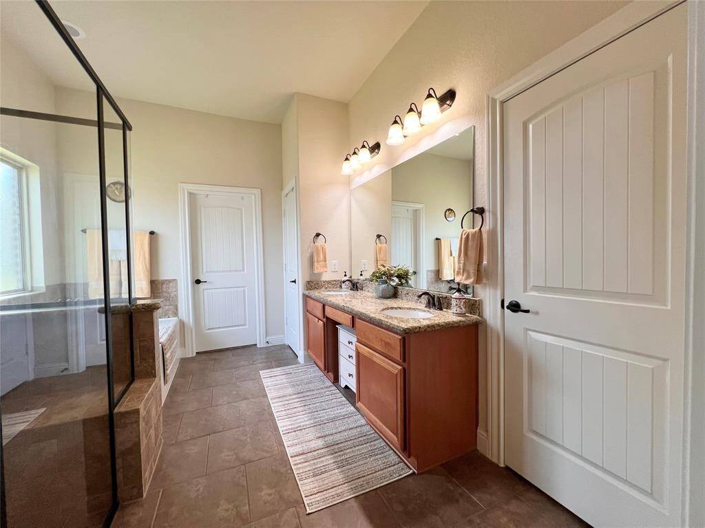 TWO-SIDE VANITY WITH UPDATED LIGHTING, GRANITE COUNTER, AND UNDER MOUNT SINKS. AMPLE SPACE FOR DANCING.