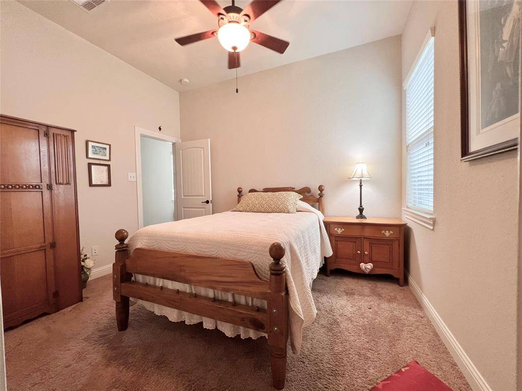 SPACIOUS SECONDARY BEDROOM WITH SOFT CARPETING, AN ACCOMMODATING CLOSET, NATURAL LIGHT, CEILING FAN, AND 2" BLINDS