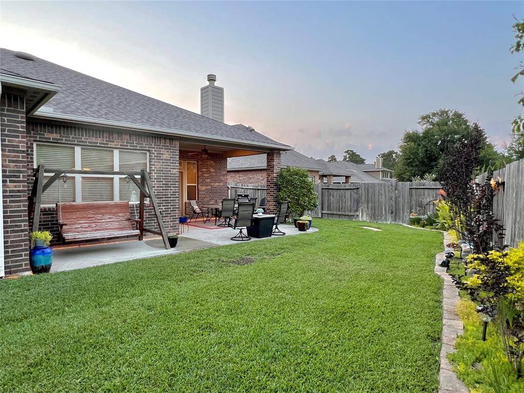 LARGE BACKYARD WITH AMAZING GARDEN BORDERS CREATING A DELIGHTFUL AND CHARMING OUTDOOR AREA.  NOTICE THE PATIO EXTENSION