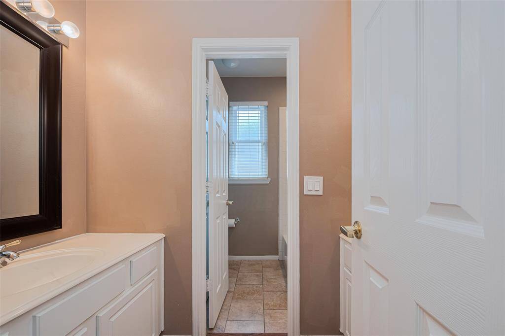 The second bathroom features dual sinks and vanities. The second sink is behind the door.