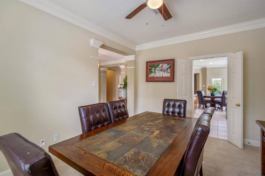 Expansive kitchen boasting a large island with seating, ample natural light from large windows, a dining area, and stainless steel appliances.