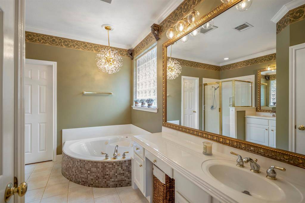 Expansive primary bedroom with crown molding, and a private en suite bathroom.
