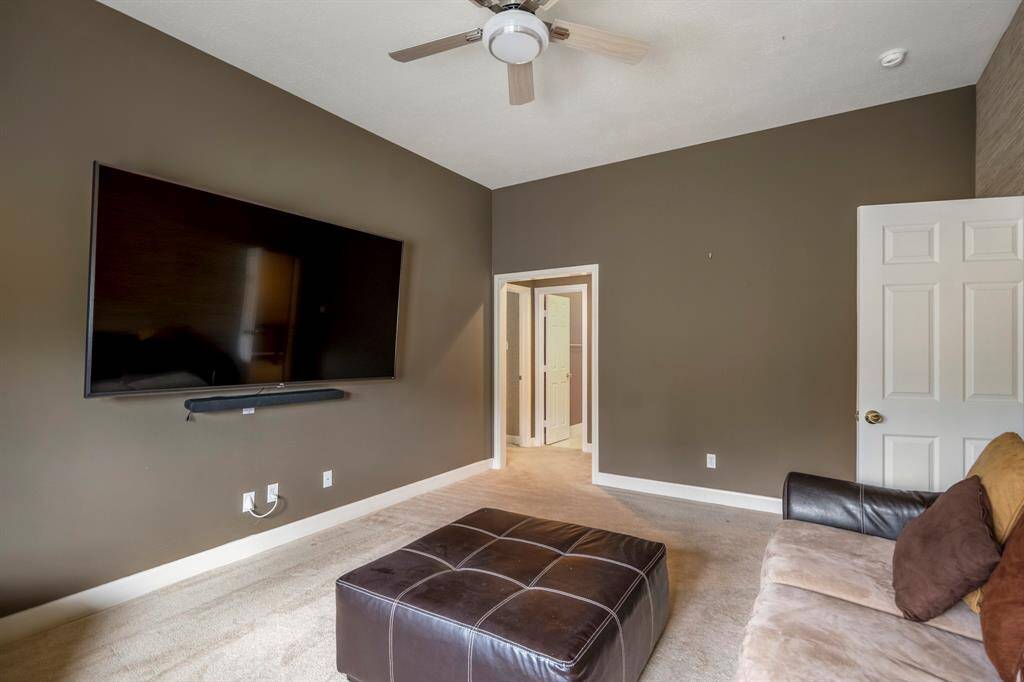 Upstairs multipurpose room featuring high ceilings, a ceiling fan, large windows that fill the space with natural light, and versatile space ideal for a variety of activities.