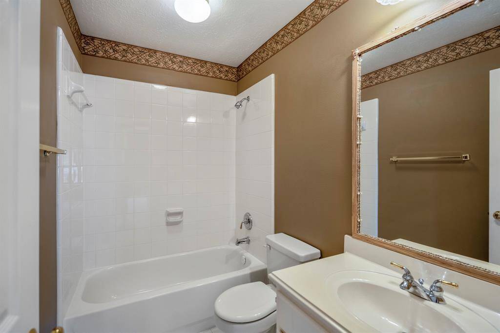 Upstairs versatile room with high ceilings, ceiling fan, and large windows providing abundant natural light—perfect for multiple uses and activities.