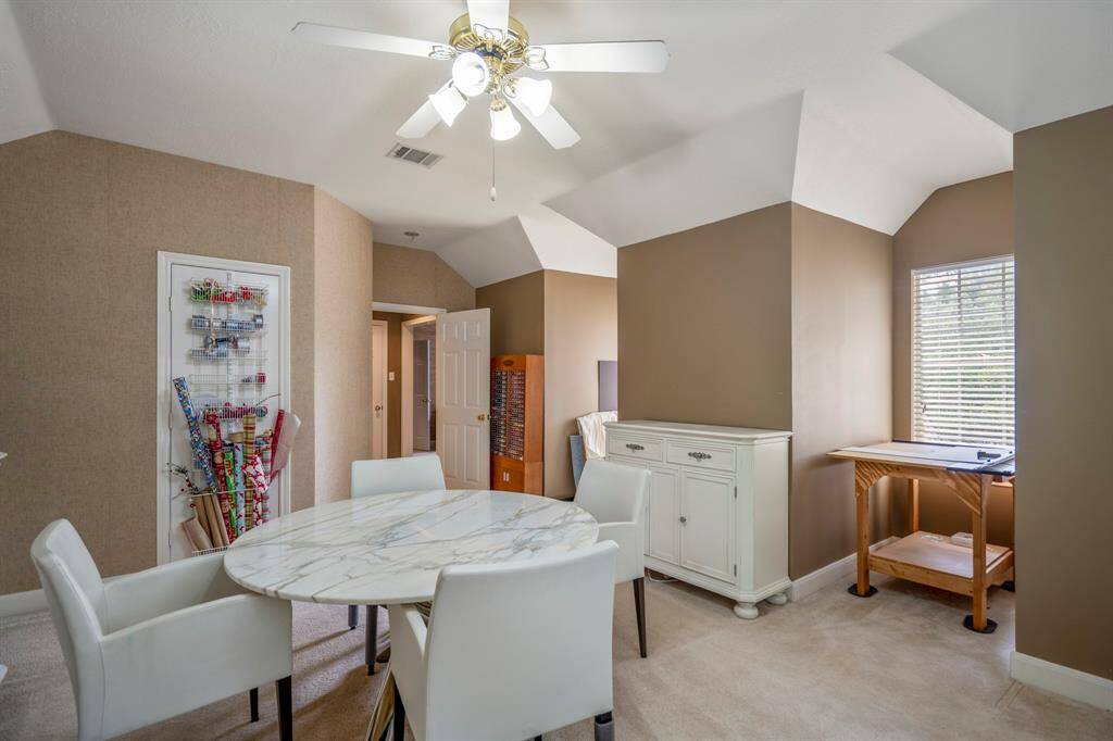 Spacious bedroom currently used as a craft room, filled with natural light from large windows and featuring plush carpeting for comfort.