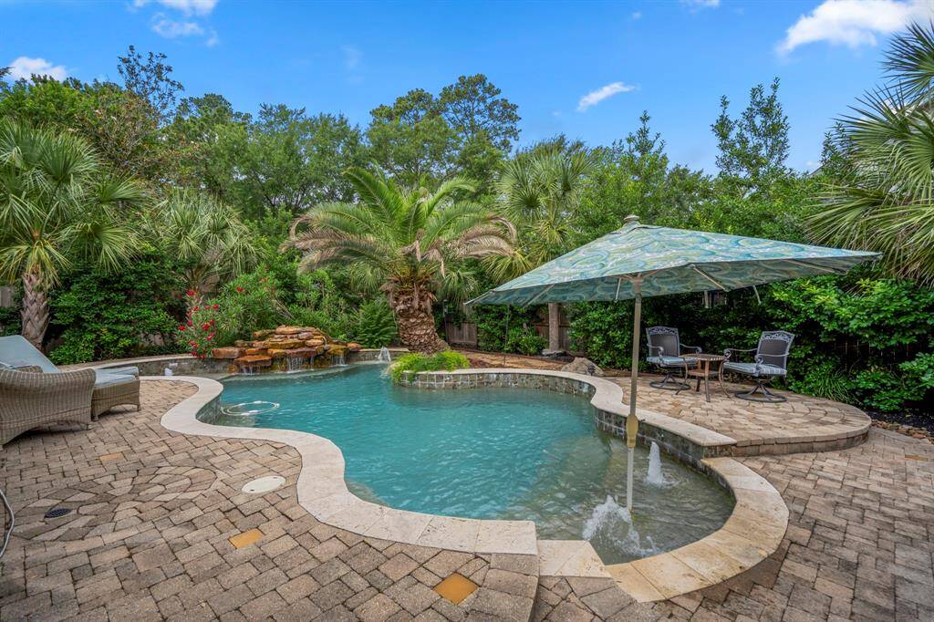 Charming two-story brick home with warm exterior lighting, a well-maintained front lawn, mature trees, and welcoming entrance.