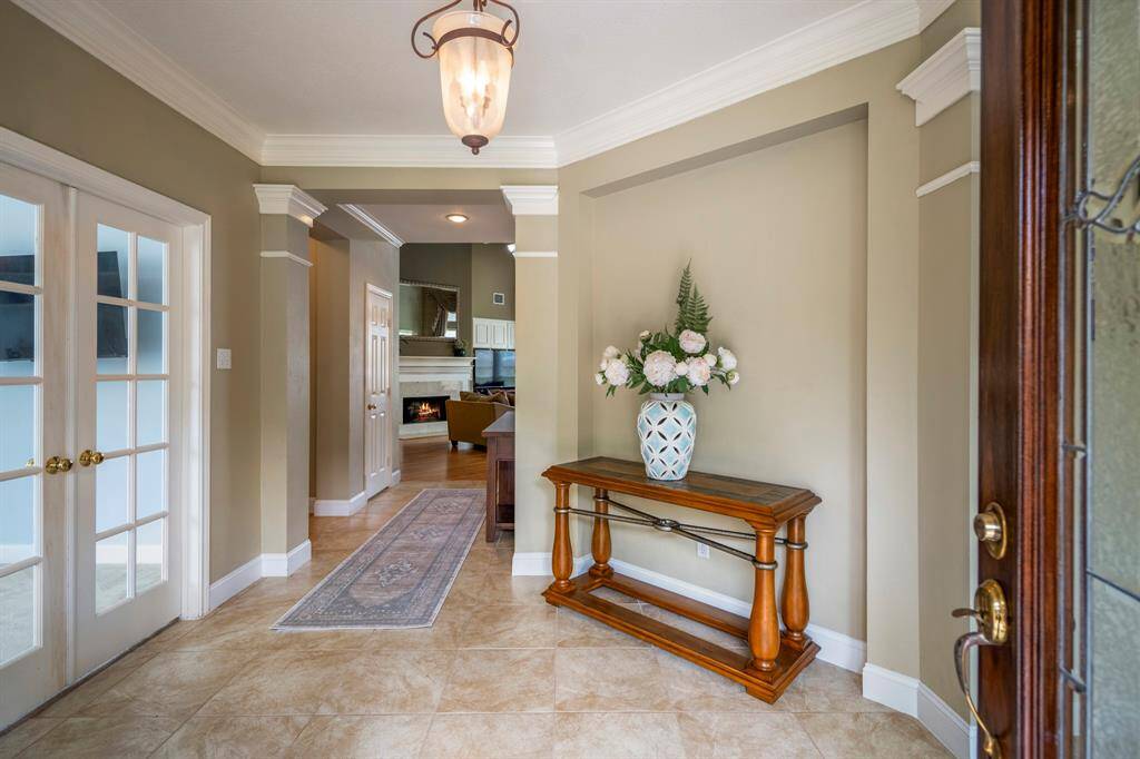 Elegant entryway showcasing detailed crown molding and a warm, welcoming atmosphere.