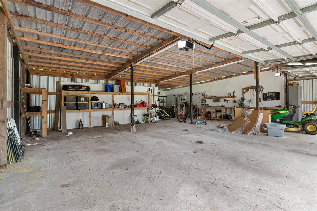 3 car garage features extra work area in back as well as additional shelving and work bench.