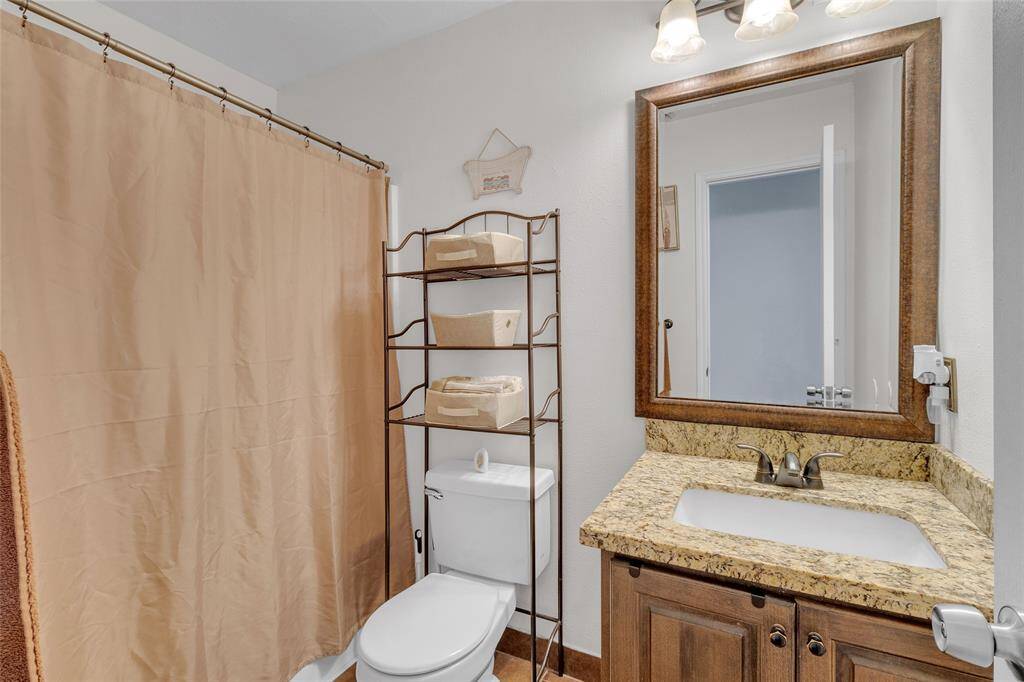 Charming Guest Bathroom: Featuring modern fixtures, elegant granite countertops, and ample storage space.