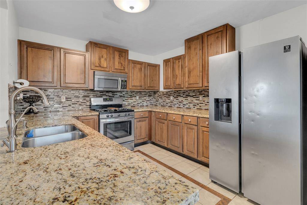 Chic Gourmet Kitchen with Granite Countertops and Modern Appliances