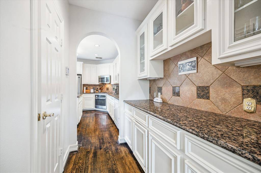 Luxurious butler’s pantry featuring granite countertops and stylish cabinetry.