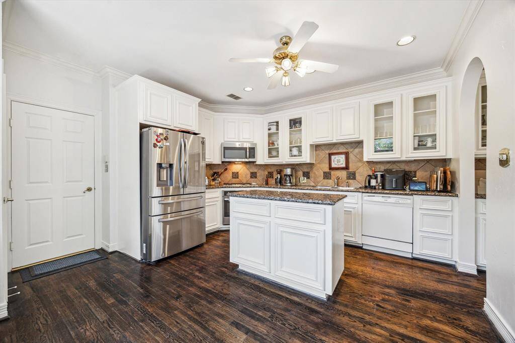 Inviting kitchen featuring granite countertops, a gas stove, and a central island.