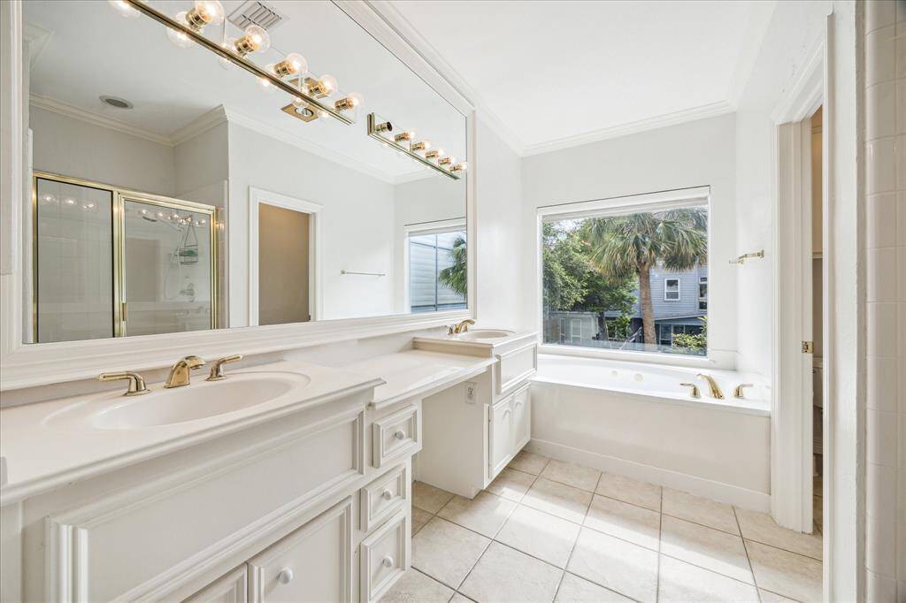 Luxurious en-suite bathroom featuring double sinks, a jetted tub, and a spacious shower.