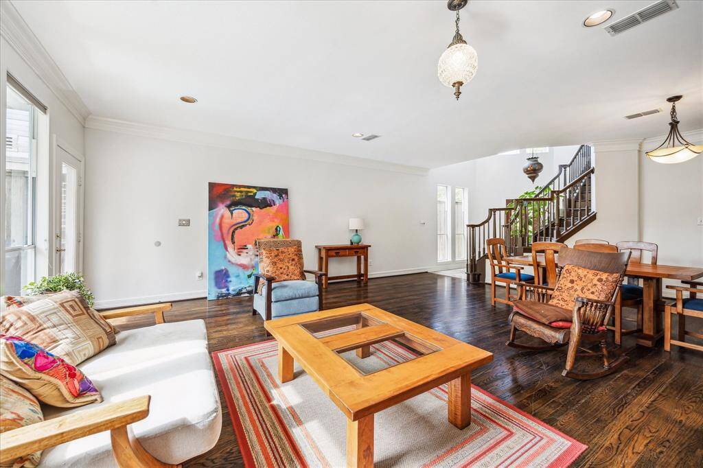 Experience elegance in the living and dining area, featuring stunning staircase railings and distinctive hanging lamps.