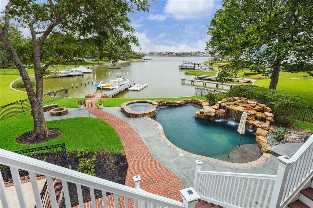 Resort Style Backyard! Heated pool, hot tub, waterfall with grotto, plenty of lounging or dining space, and a gas firepit will keep your weekends busy! Just hop on a boat or kayak for some afternoon fun on the water!