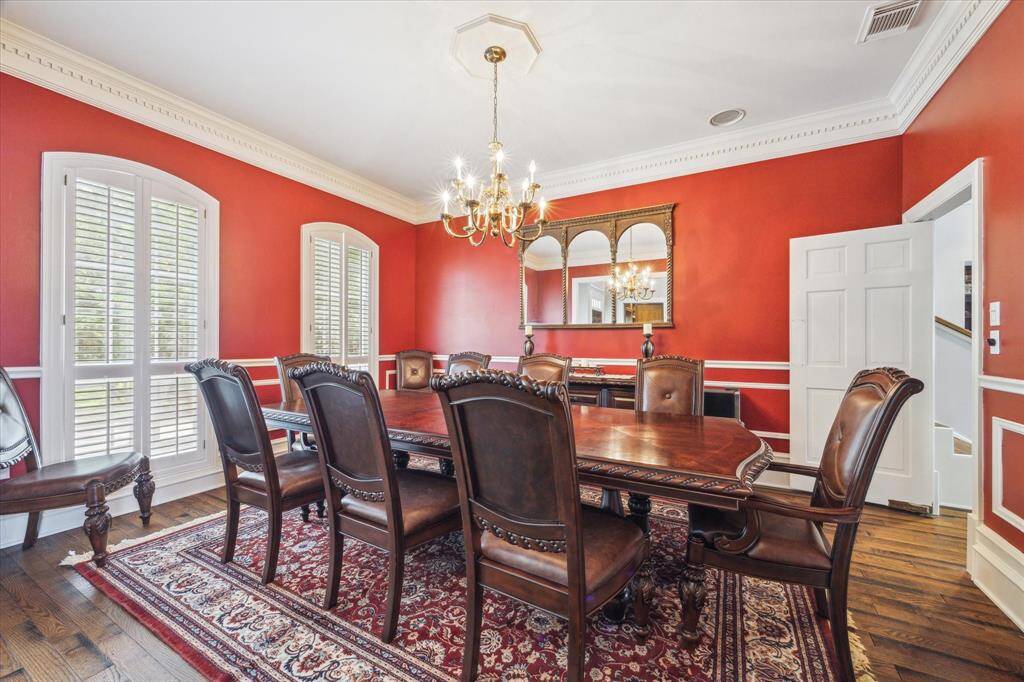 Classic Dining Room with plenty of room for large furniture.  (in fact, this furniture is included if you want it!)  Swing door takes you thru to the kitchen.  Notice the custom crown molding, baseboards and shutters!