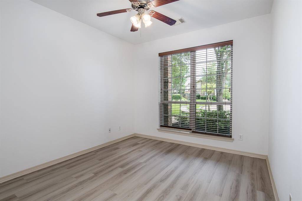 Bright and comfortable looking at the landscape, the secondary bedroom offers a cozy retreat with plenty of natural light and flexible space for guests, a home office, or family members.