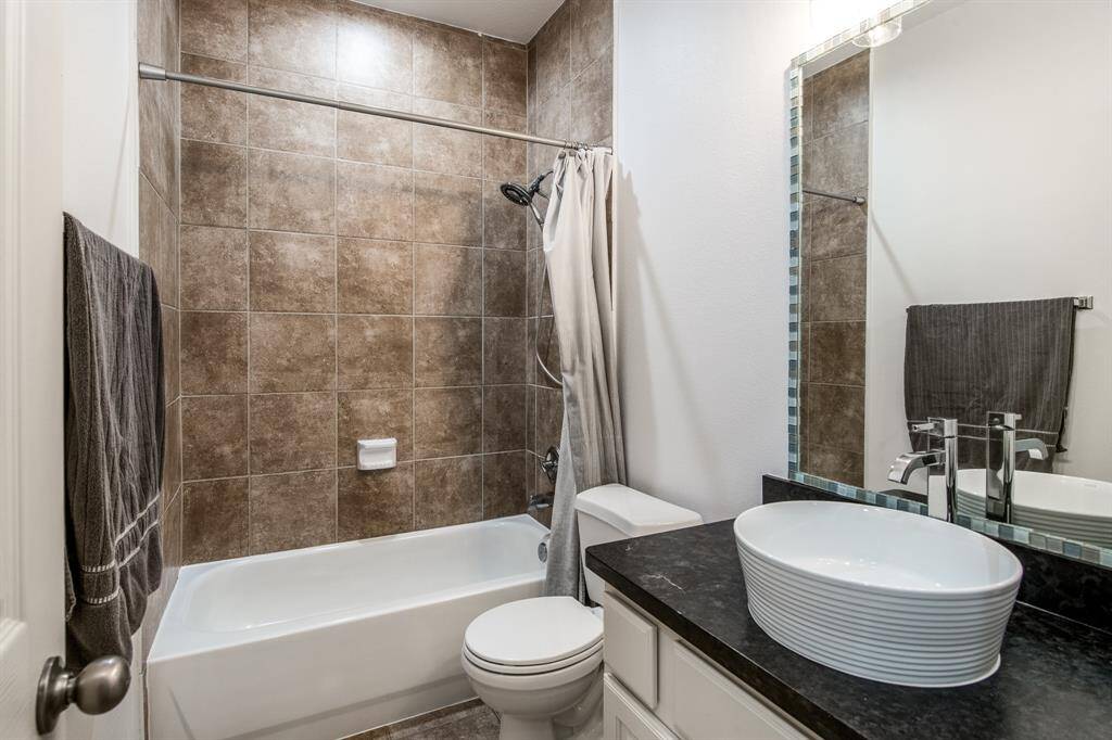 This well-appointed secondary bathroom features a clean design with a combination tub and shower—perfect for guests or everyday family use.