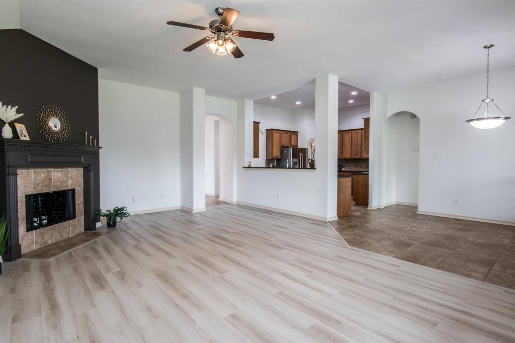 Cozy and full of charm, this living room features new flooring, a warm fireplace, abundant natural light, and a welcoming layout perfect for relaxing or entertaining.