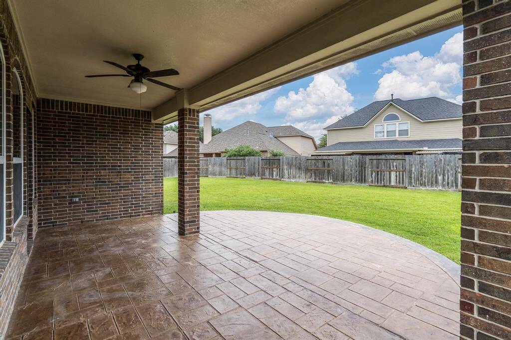 The spacious patio overlooks a large backyard, creating an ideal outdoor space for relaxing, entertaining, and enjoying nature.