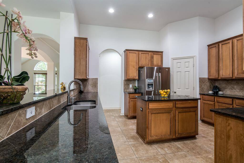 Spacious and functional, this kitchen boasts abundant cabinet storage, a center island, and a layout perfect for cooking and entertaining.
