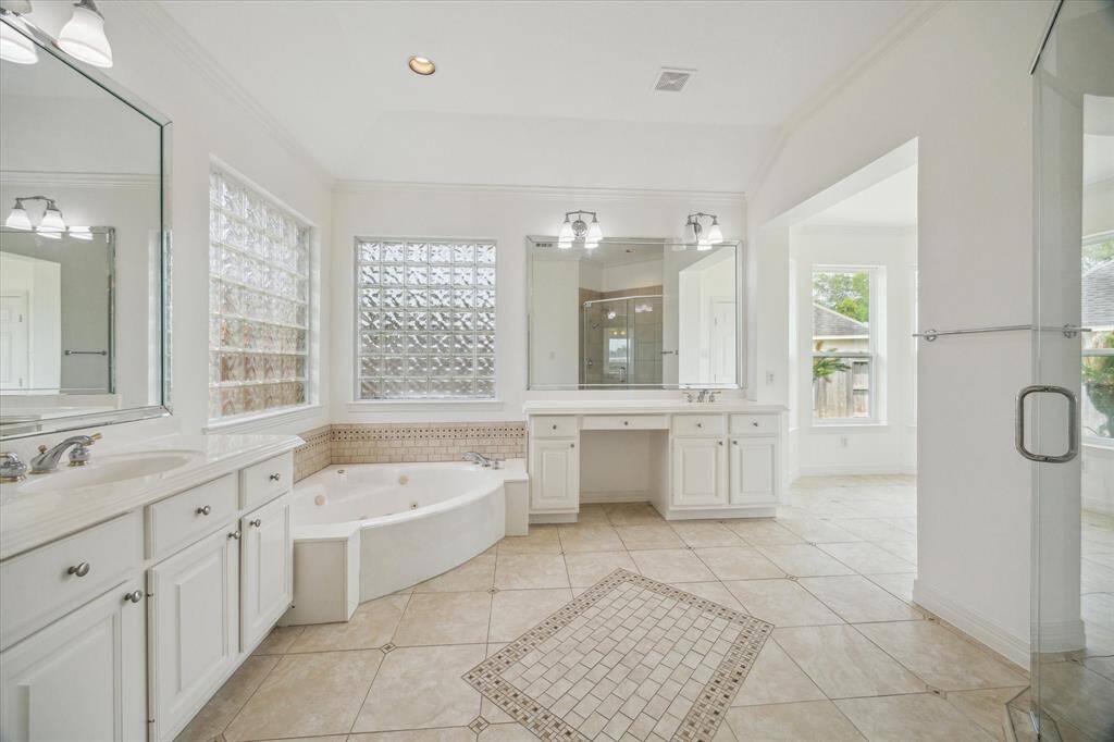Primary Bathroom features his/her vanities, plenty of storage, standing shower, tub and a large walk in closet!